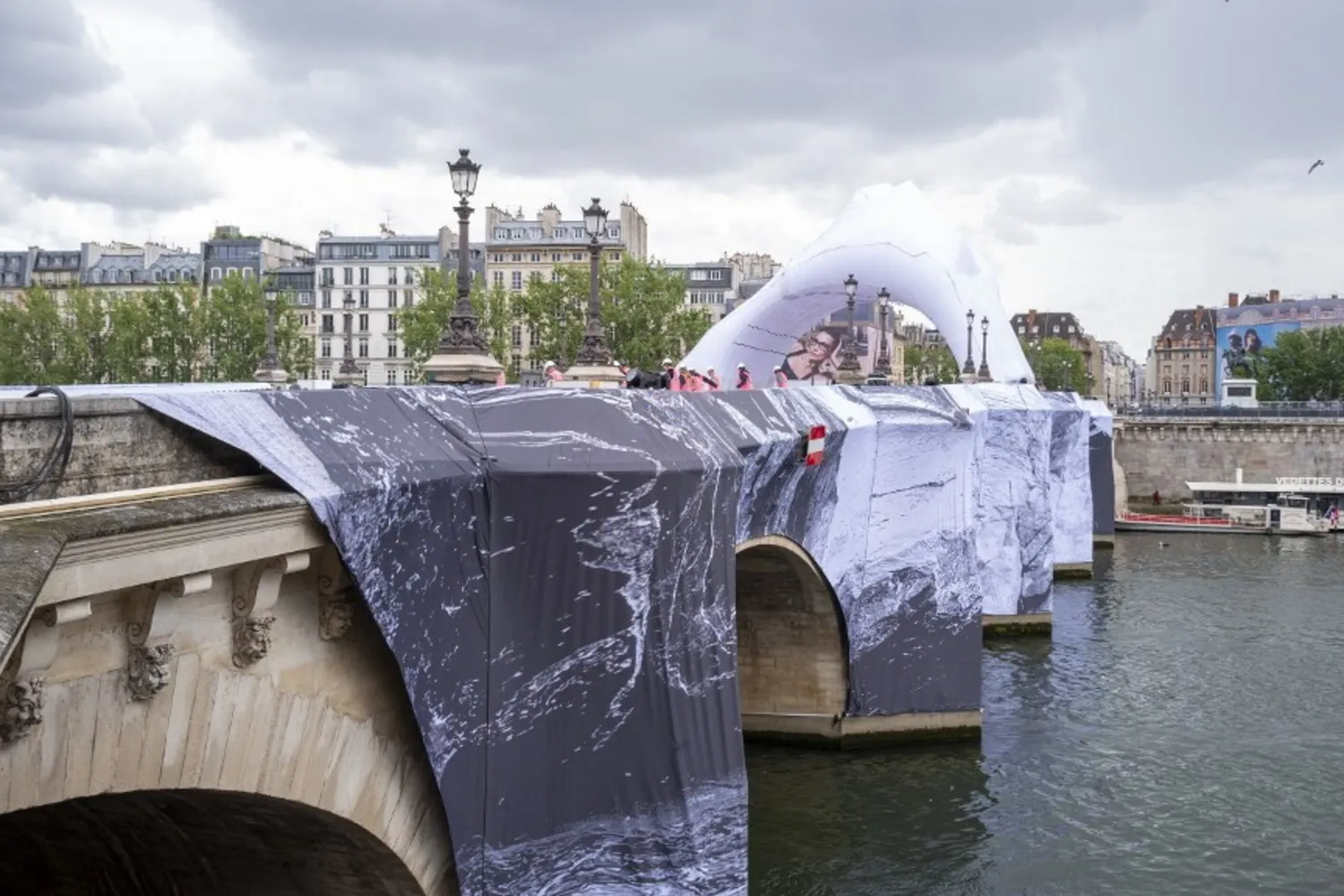 “Il Pont Neuf diventa una grotta: JR trasforma Parigi in un’installazione monumentale tra arte, illusioni e memoria”